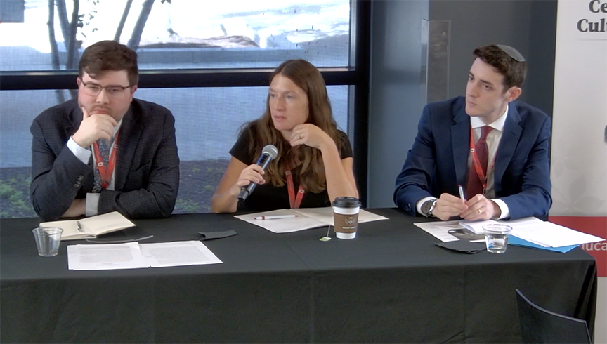 3 panelists sitting at a table