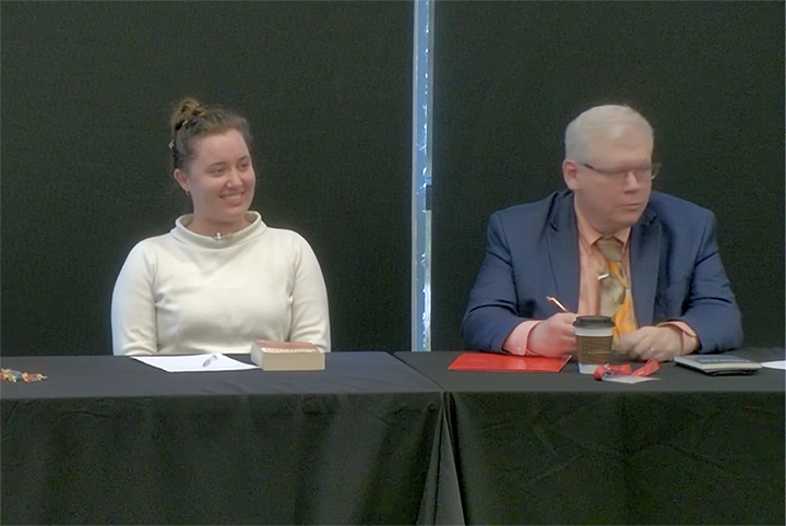 Panelists, man and woman at a table