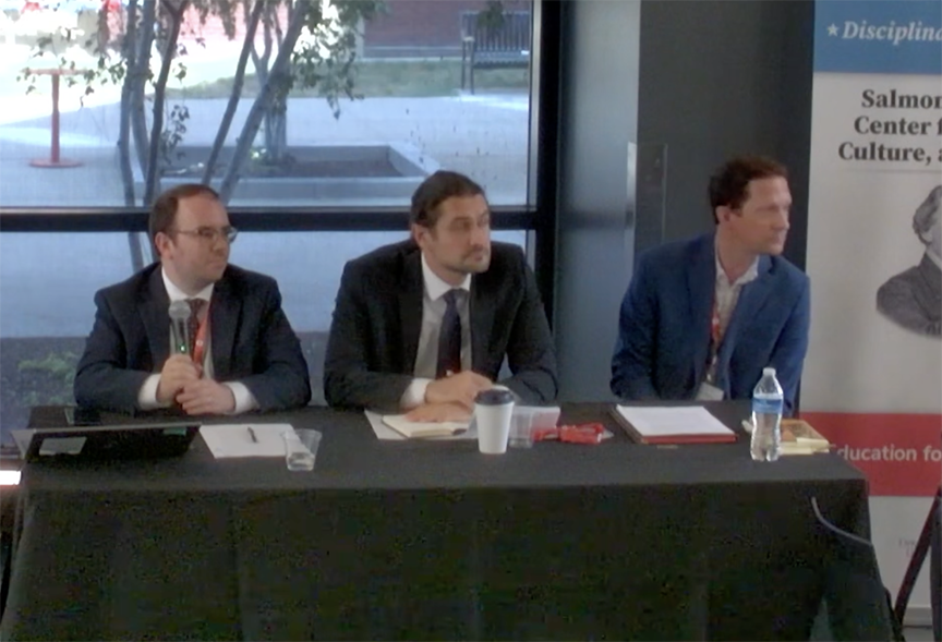 Panelists, three men at a table
