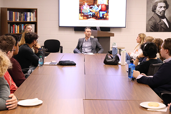 Students gather round a table for discussion at a Chase Society event