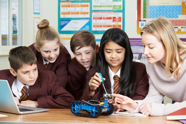 Teacher and students working on a robot