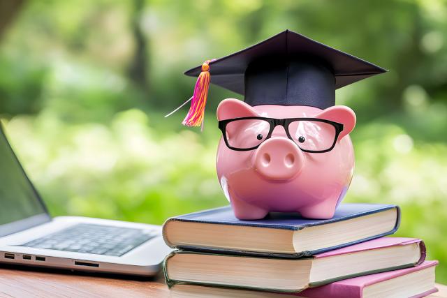 Piggy bank with graduation cap and textbooks