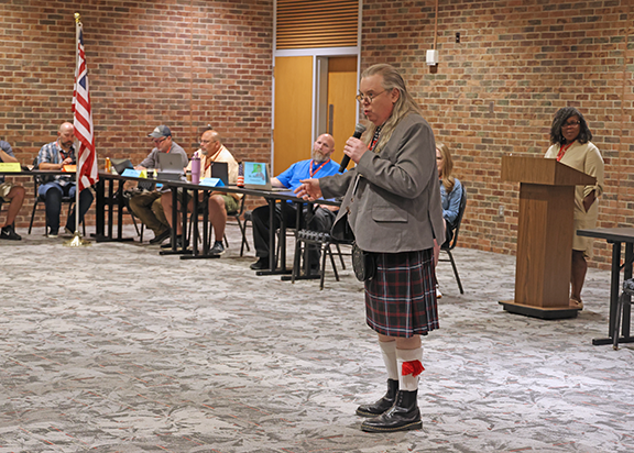 A teacher dressed as Ben Franklin addresses colleagues